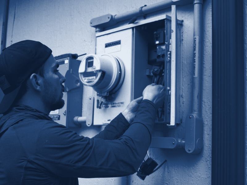 An electrician working on a home's electric meter